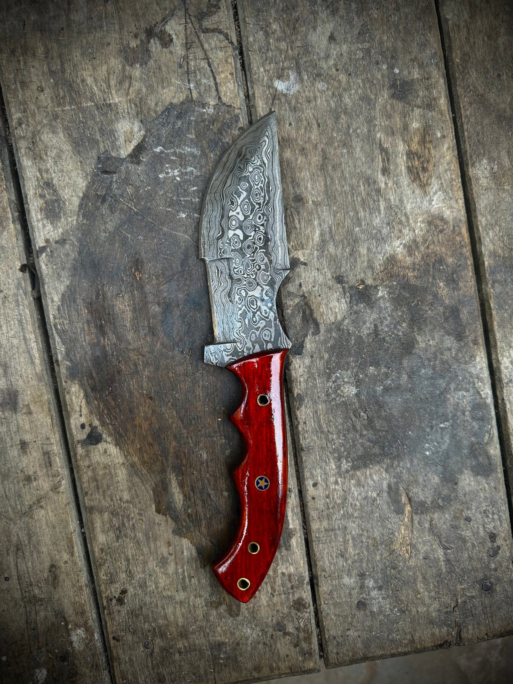 Custom Handmade Damascus Steel Tracker Knife with red Micarta Handle and leather sheath.